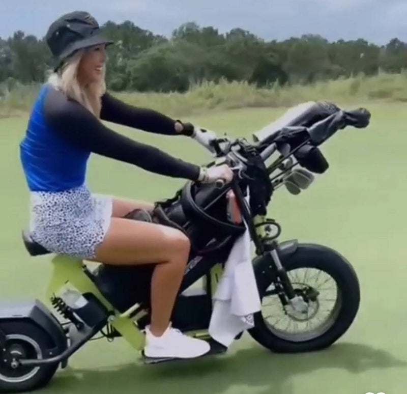 Female golfer riding Eahora M6G Electric golf caddy with golf clubs. Free shipping at E-Boarders.com