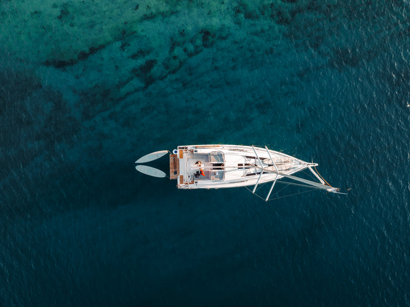 SIPA Boards Neo and Tourer Electric Paddleboard with self-inflating design and assist power unit floating on the water with sailboat. Ships free from e-boarders.com.