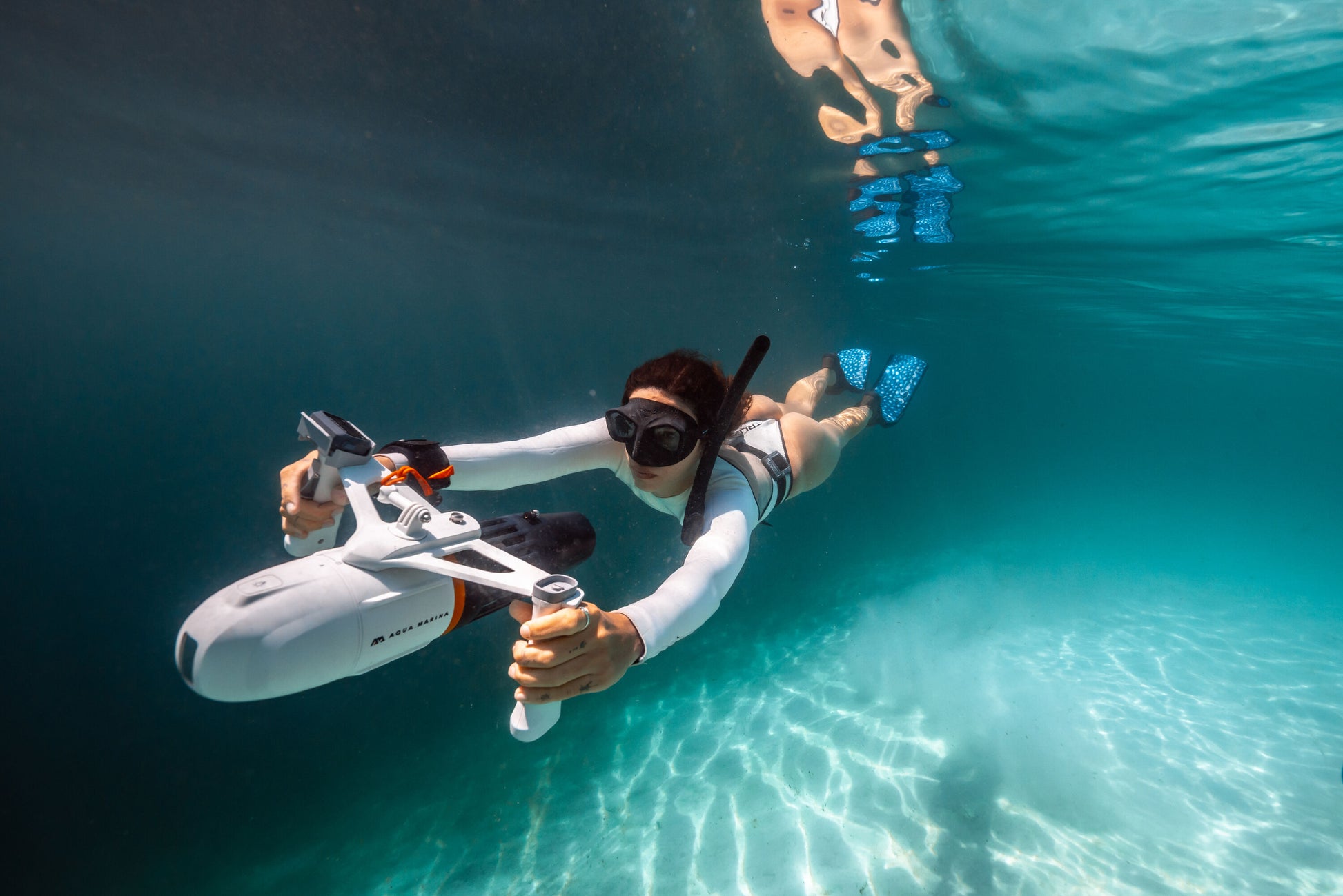 Woman underwater surface swimming with handheld Aqua Marina BLUEDRIVE X Pro. Free shipping at e-boarders.com