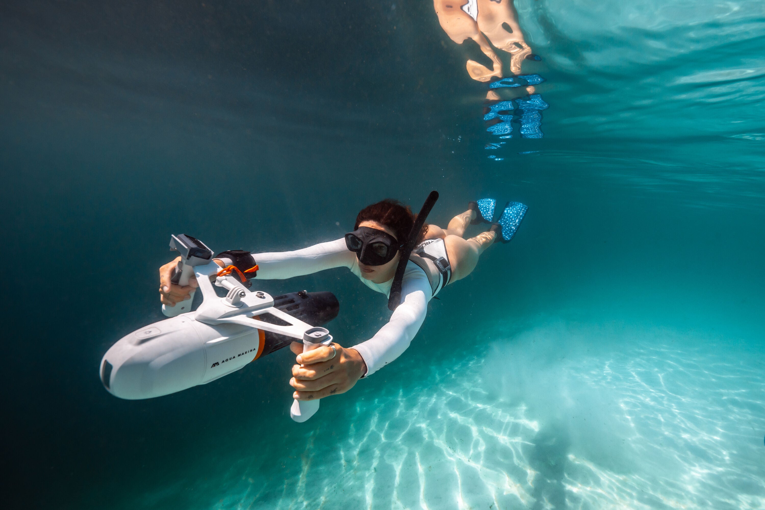 Woman underwater surface swimming with handheld Aqua Marina BLUEDRIVE X Pro. Free shipping at e-boarders.com