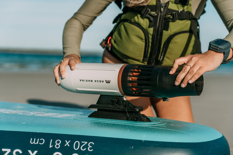 Person attaching Aqua Marina BLUEDRIVE X Pro to paddleboard middle fn adaptor. Free shipping at e-boarders.com