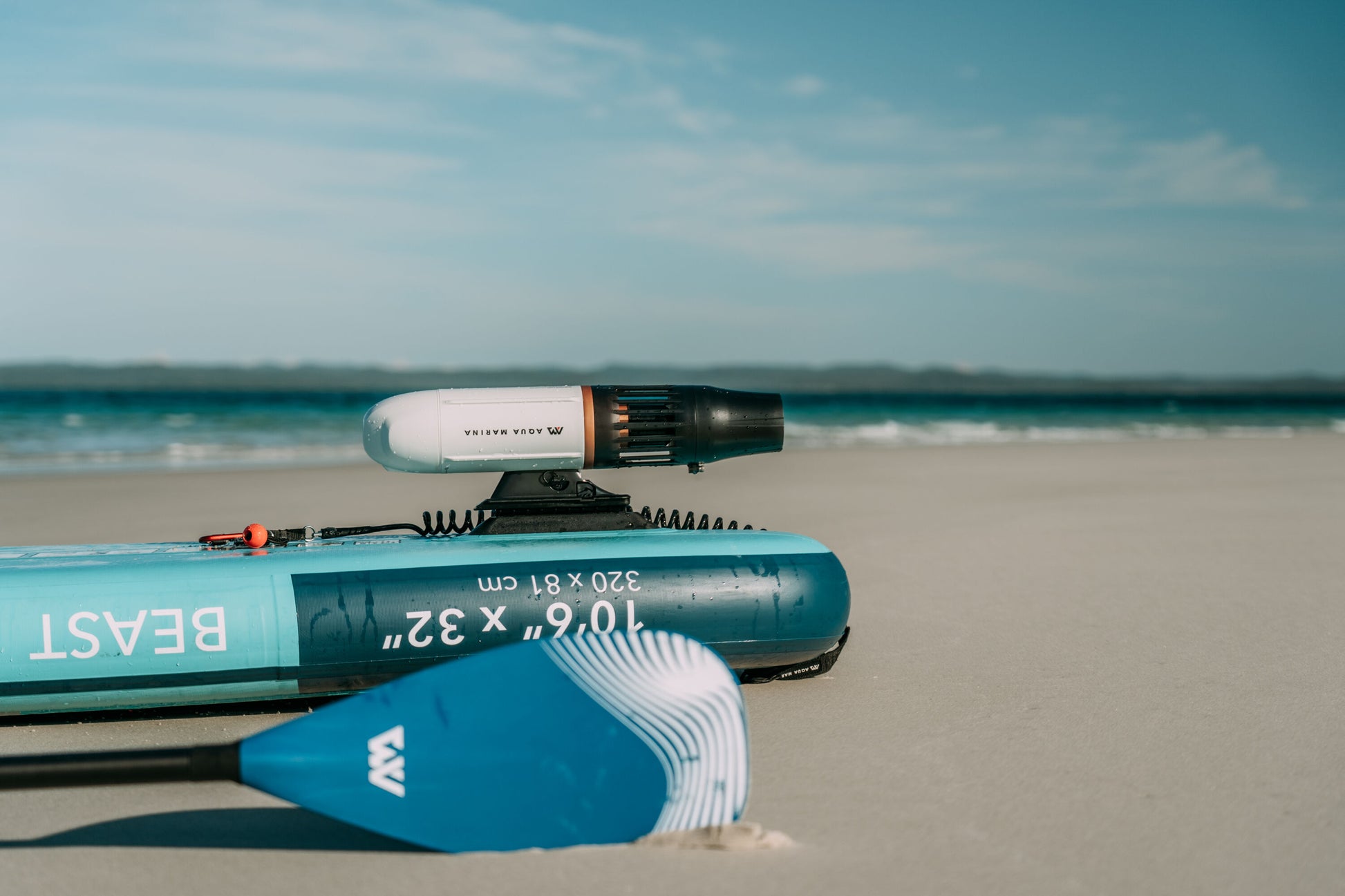 Aqua Marina BLUEDRIVE X Pro mounted to paddleboard middle fn adaptor on the beach. Free shipping at e-boarders.com