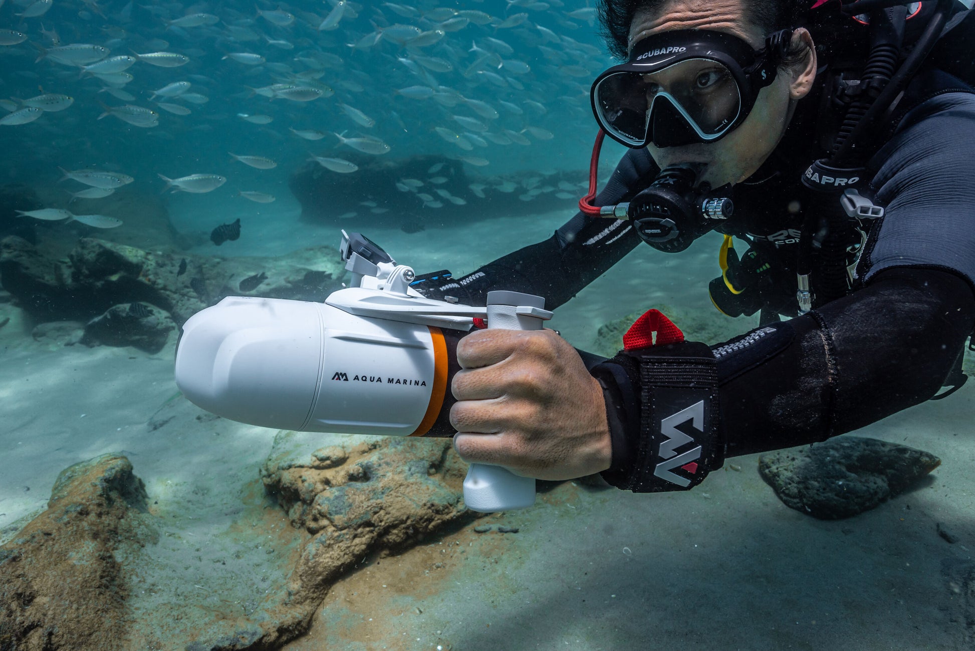 Diver holding the Aqua Marina BLUEDRIVE X Pro electric-assist fin system. Free shipping at e-boarders.com