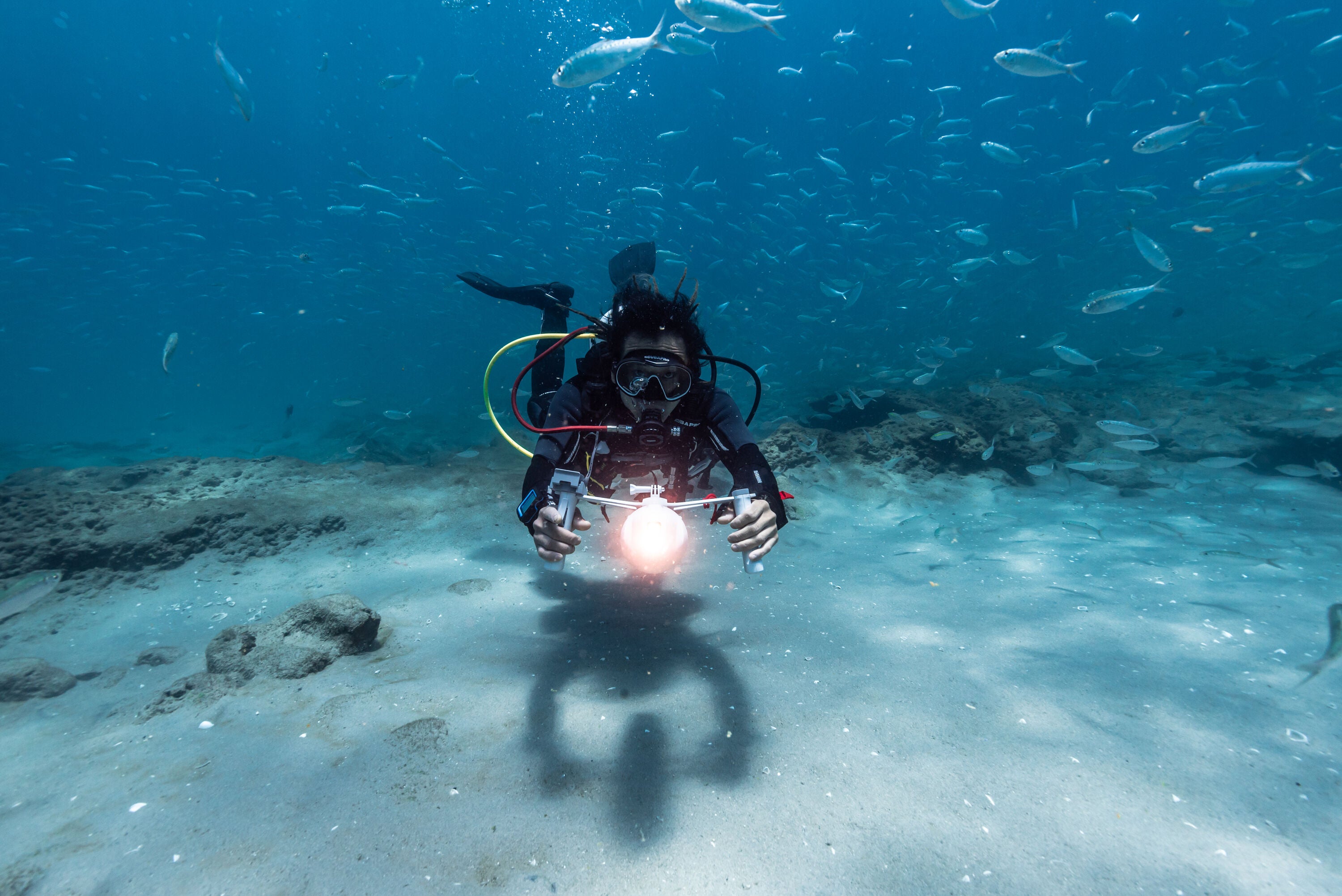 Diver holding Aqua Marina BLUEDRIVE X Pro electric-assist fin system. Free shipping at e-boarders.com