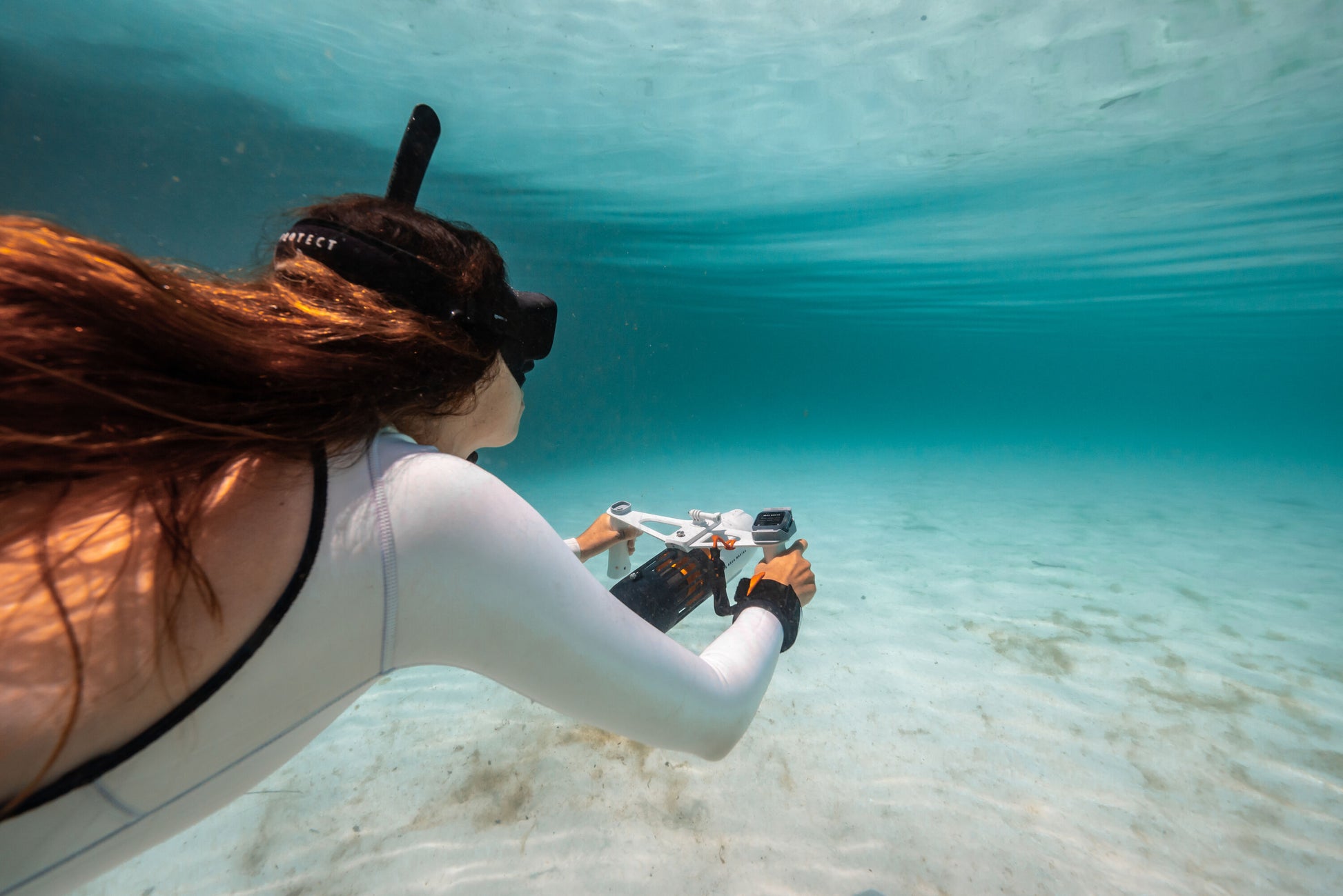 Woman underwater surface swimming with handheld Aqua Marina BLUEDRIVE X Pro. Free shipping at e-boarders.com