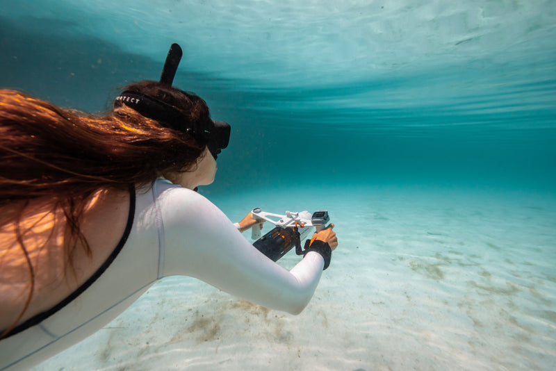 Woman underwater surface swimming with handheld Aqua Marina BLUEDRIVE X Pro. Free shipping at e-boarders.com