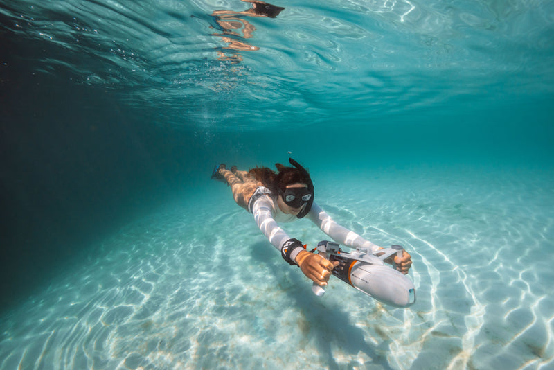 Woman snorkeling underwater with handheld Aqua Marina BLUEDRIVE X Pro. Free shipping at e-boarders.com