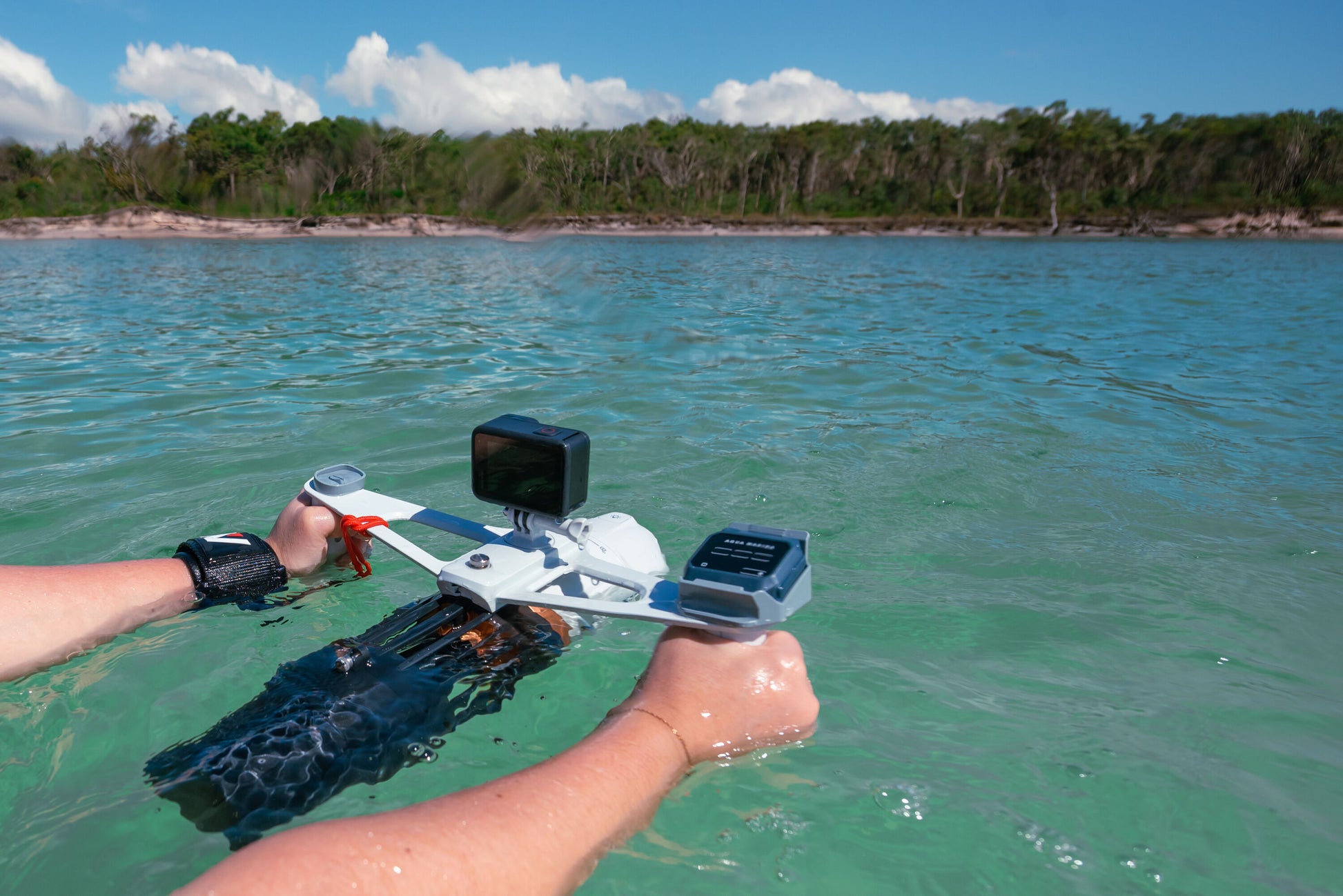 Swimmer in water with GoPro camera mounted to Aqua Marina BLUEDRIVE X Pro electric-assist fin system. Includes wireless remote control and rechargeable battery. Designed for paddleboarders, snorkelers, and recreational swimming. Free shipping at e-boarders.com