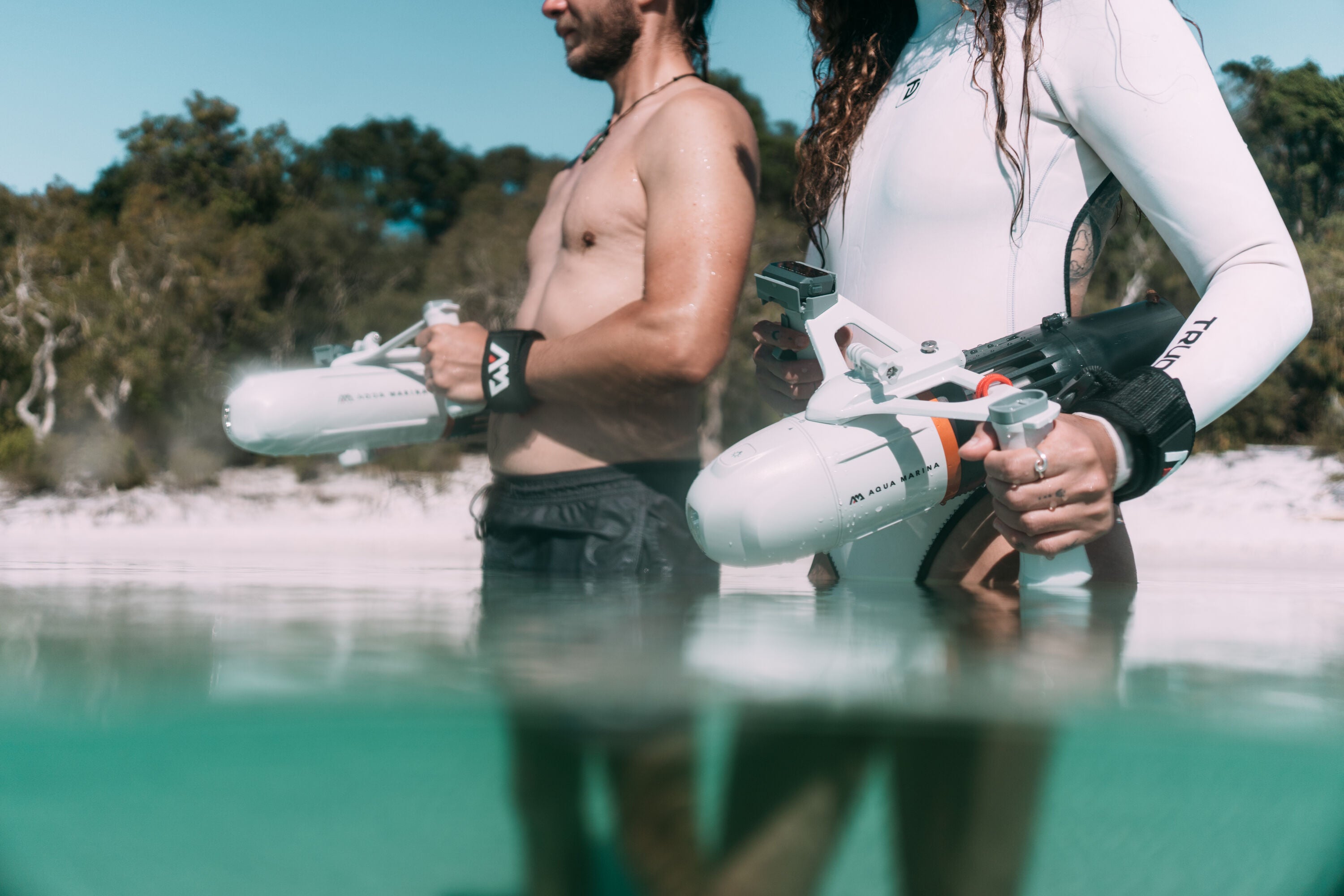 Man and woman holding Aqua Marina BLUEDRIVE X Pro entering water. Free shipping at e-boarders.com