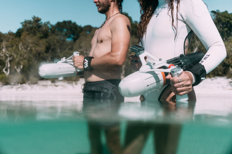 Man and woman holding Aqua Marina BLUEDRIVE X Pro entering water. Free shipping at e-boarders.com