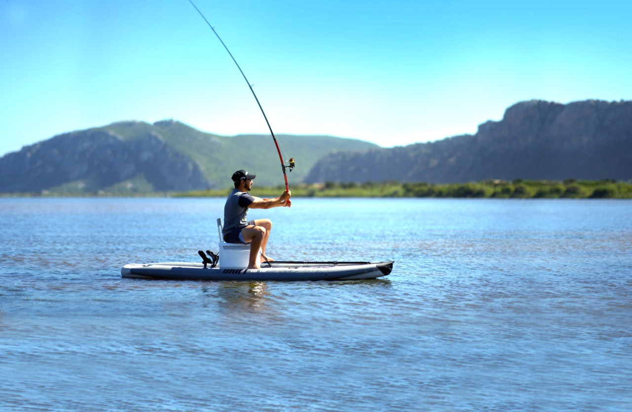 Lifestyle photo man casting a fishing rod line on Aqua Marina Drift iSUP with rod holder — ships free at e-boarders.com