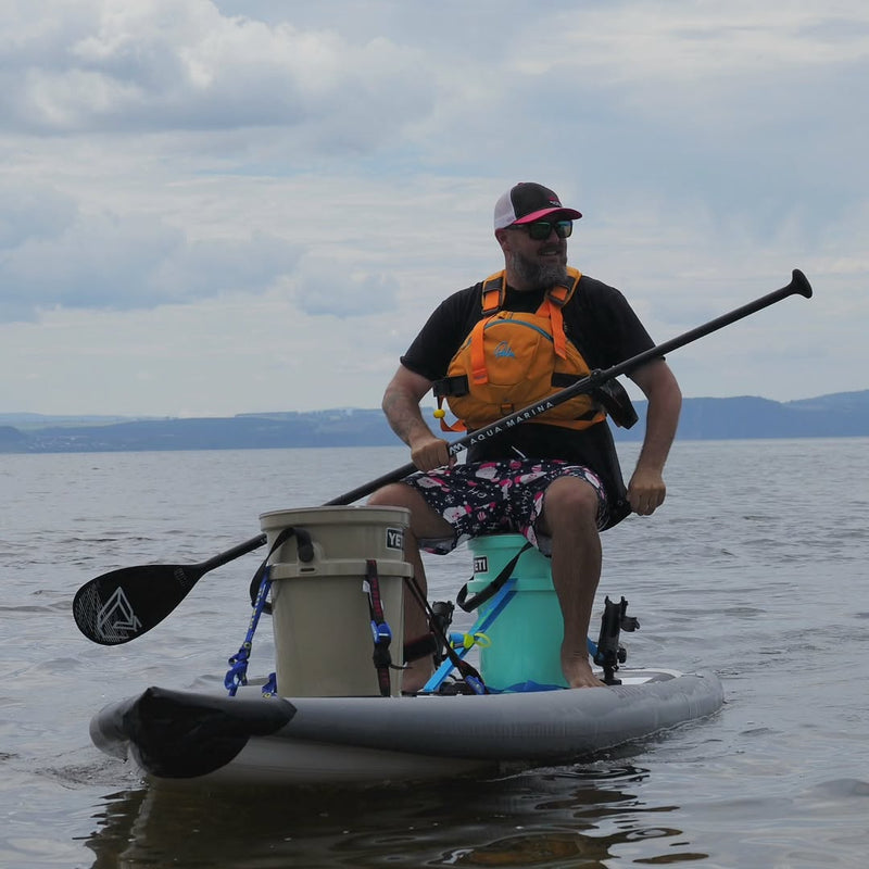 Lifestyle photo man sitting on Aqua Marina Drift iSUP with rod holder — ships free at e-boarders.com