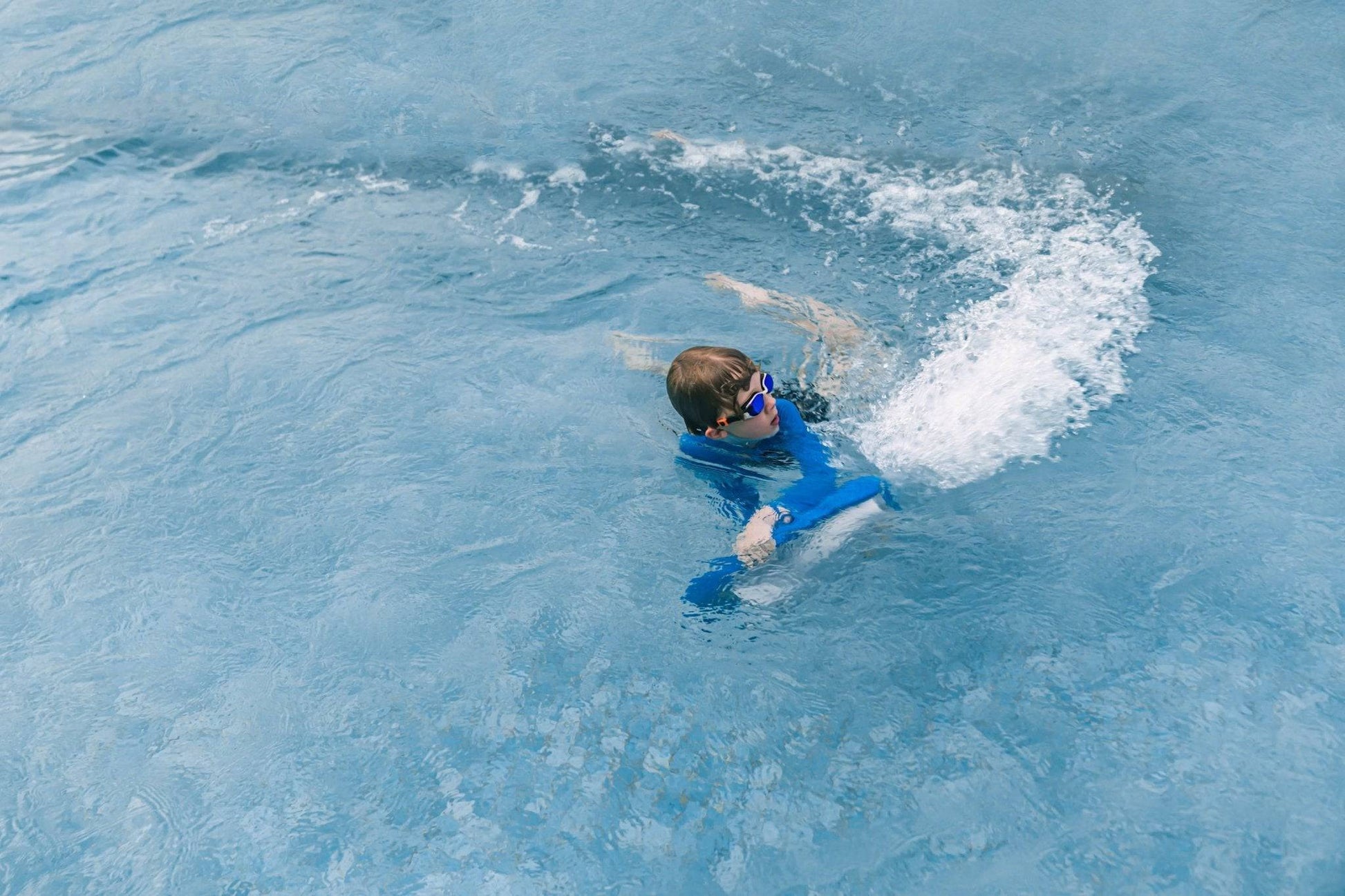 Swimmer in a pool wiht ASIWO MAKO electric swimming kickboard in blue for aquatic swim assistance. Ships free at e-boarders.com