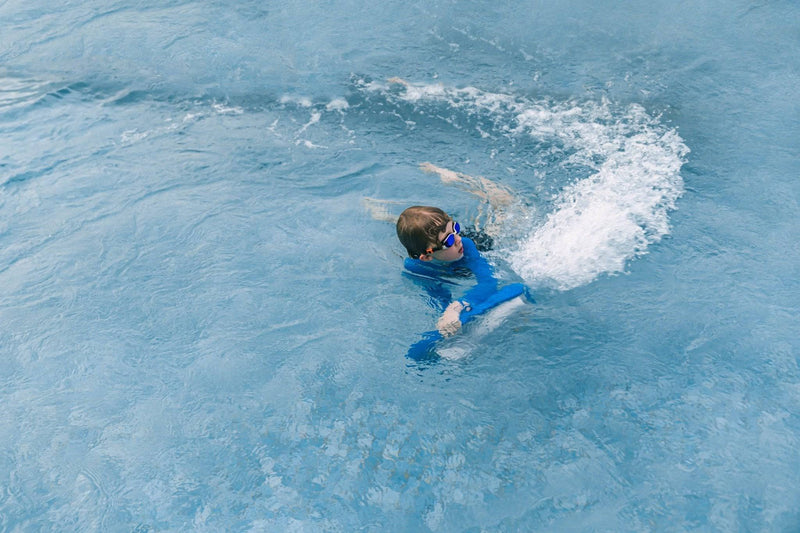 Swimmer in a pool wiht ASIWO MAKO electric swimming kickboard in blue for aquatic swim assistance. Ships free at e-boarders.com