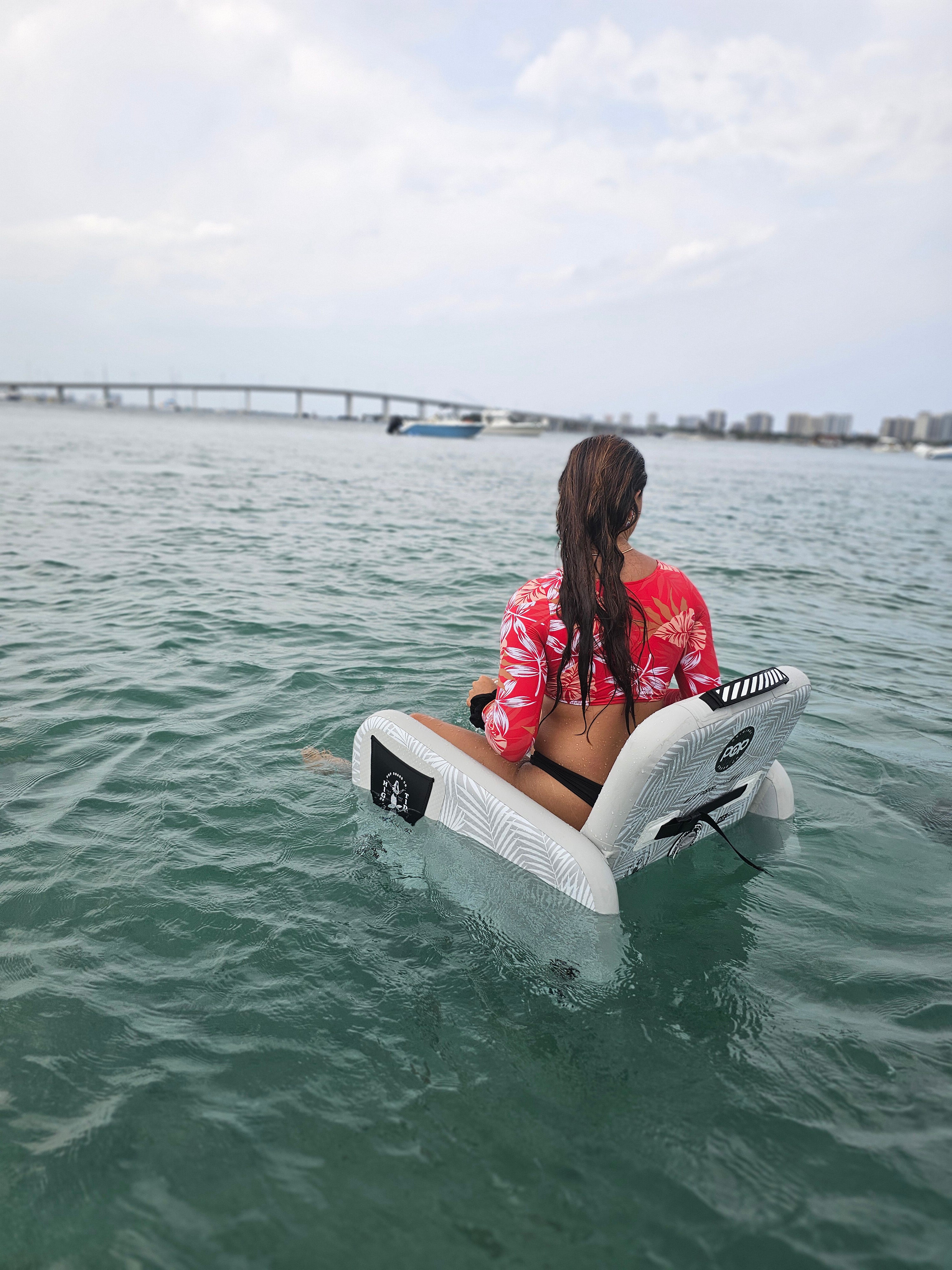 PopBoard Inflatable chair floating in the water with a female sitting in the water, available at e-boarders.com