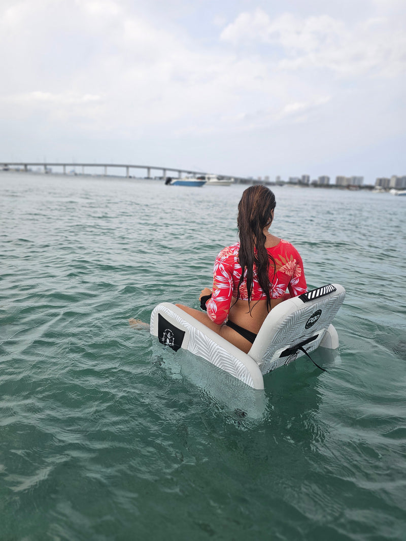 PopBoard Inflatable chair floating in the water with a female sitting in the water, available at e-boarders.com