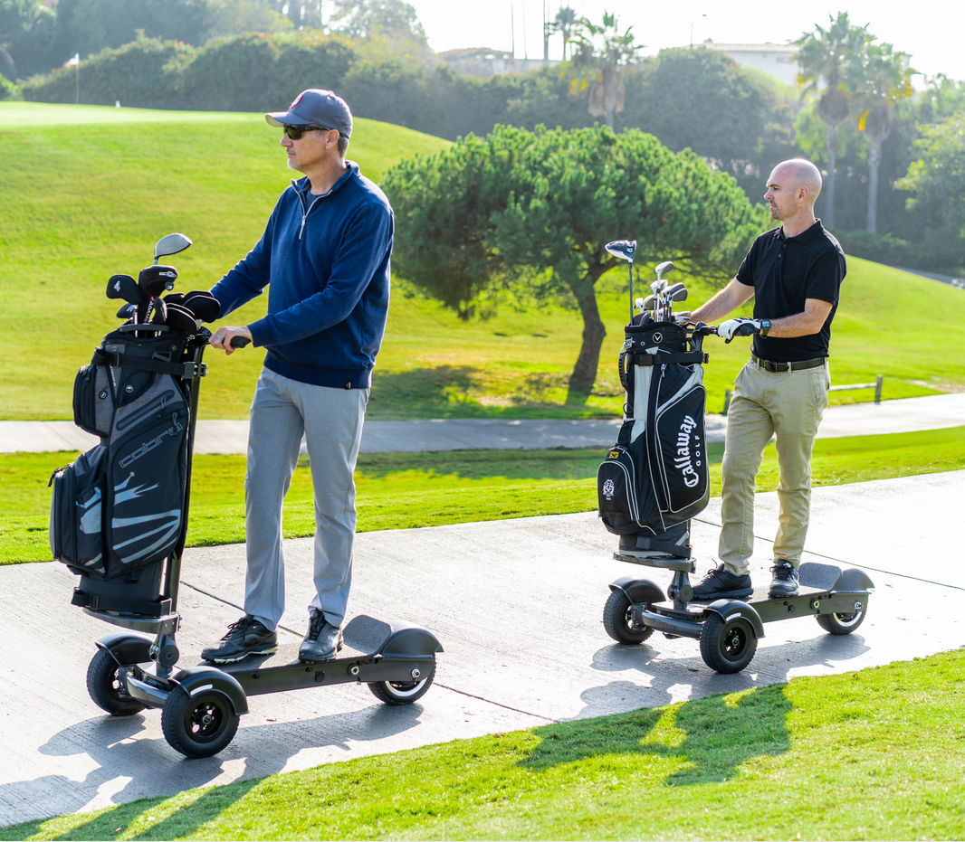 E-Boaders.com offers a golf bag mount that attaches to any electric scooter. Two men riding Cycleboard Rover 3-wheel Electric Scooters on a golf pathway on a golf course.